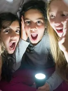 young girls with battery powered flashlight during power outage